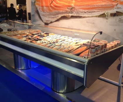 A display of various seafood products on ice, with a blue-lit base and orange backdrop.
