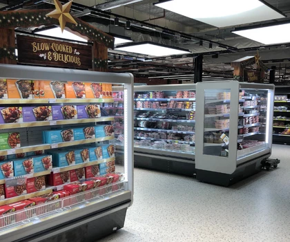 Two glass-fronted freezers display various ice cream tubs in a well-lit retail space.
