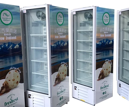 Four upright freezers with glass doors, featuring a blue and white design, displaying ice cream branding.