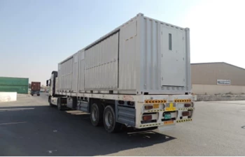 A large white shipping container truck parked on a road under a clear blue sky.