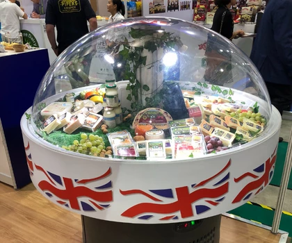 Display of British food products under a clear dome, featuring colourful packaging and a Union Jack base.