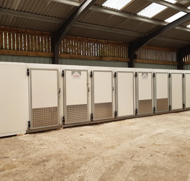 Modular walk-in cold rooms with white exteriors and metal doors, arranged in a spacious interior.