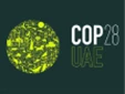 Green circular graphic featuring various environmental symbols, with "COP28 UAE" text on a dark background.
