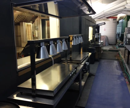 Stainless steel work surfaces with silver lamps, set in a well-lit maintenance area.