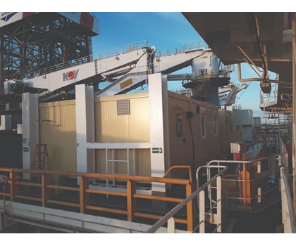 Construction site featuring a yellow container with cranes against a blue sky.