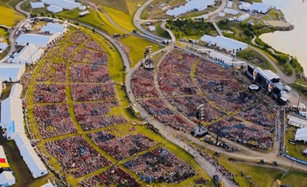 Aerial view of a vibrant festival site with colourful tents and grassy areas.
