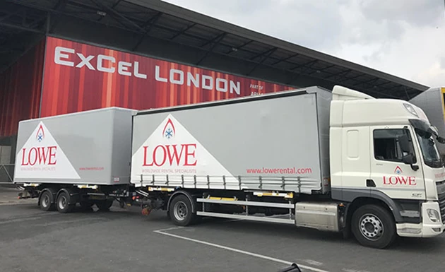 Lowe-branded trucks parked outside Excel London, featuring grey bodies and a prominent red logo.