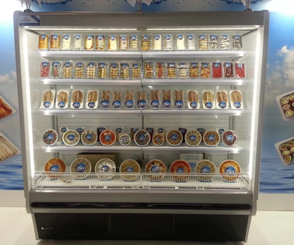 A well-lit display fridge filled with various jars and containers, predominantly in vibrant colours.