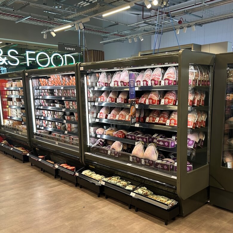 Chilled food display units filled with various packaged products in a modern retail environment.