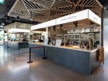 Modern café interior featuring grey counters, wooden accents, and a clean, minimalist design.