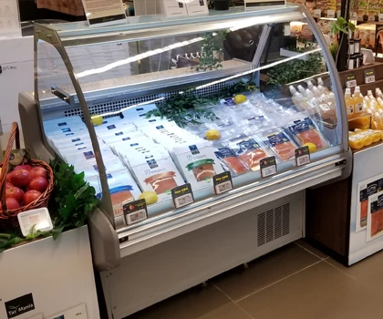 Chilled seafood display with various fish types, garnished with green herbs and lemon slices.