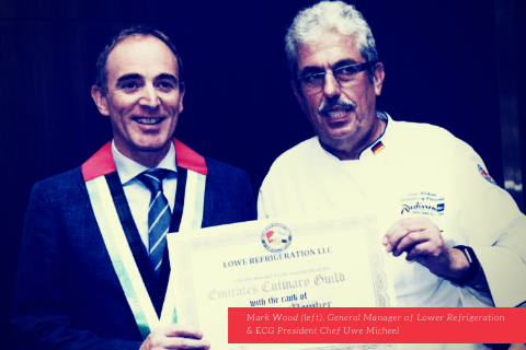 Mark Wood and Chef Omar Mahfouz hold a certificate, both smiling, in a formal setting.