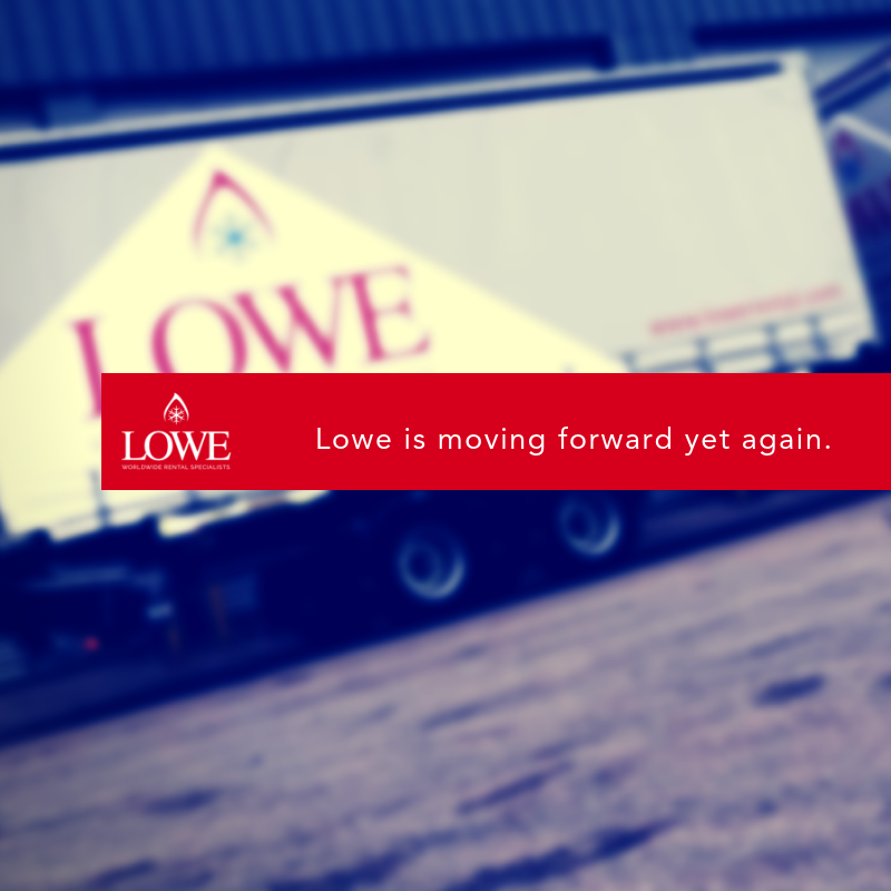 Lowe-branded truck with a yellow and white trailer parked on a gravel surface.