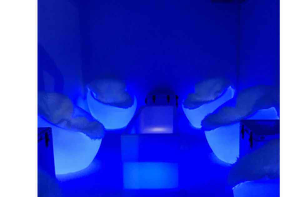 Two white objects are illuminated by blue light, creating a vibrant, modern atmosphere.