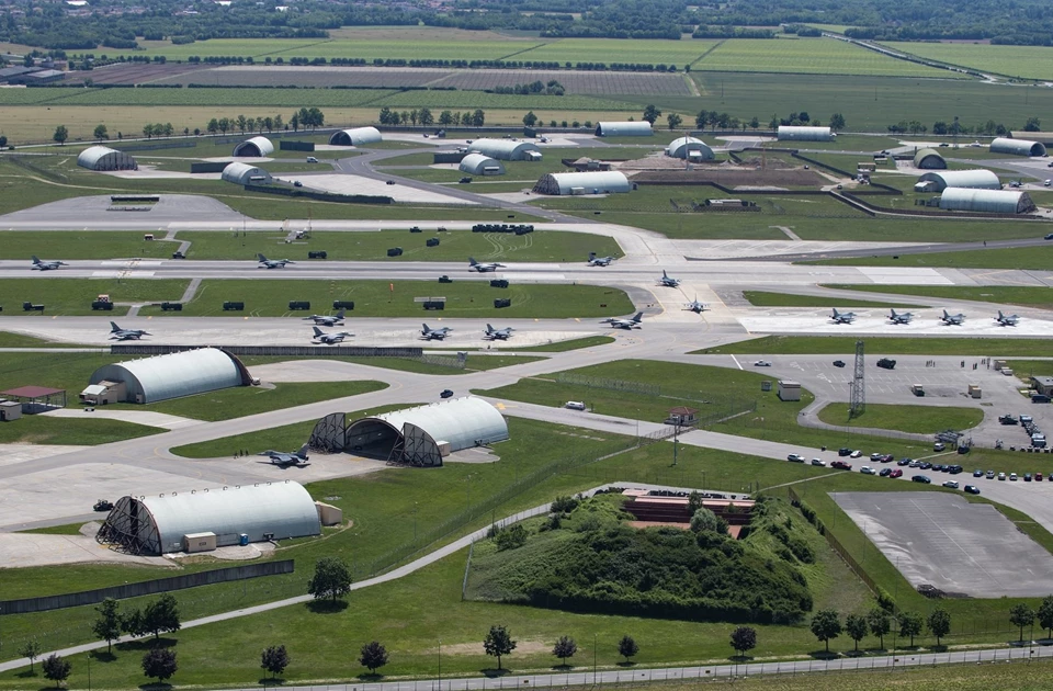 Aerial view of temporary kitchens surrounded by green fields and various structures on a large site.