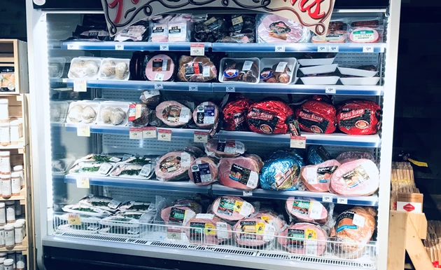 Chilled meat products displayed on shelves, featuring various colours and packaging designs.