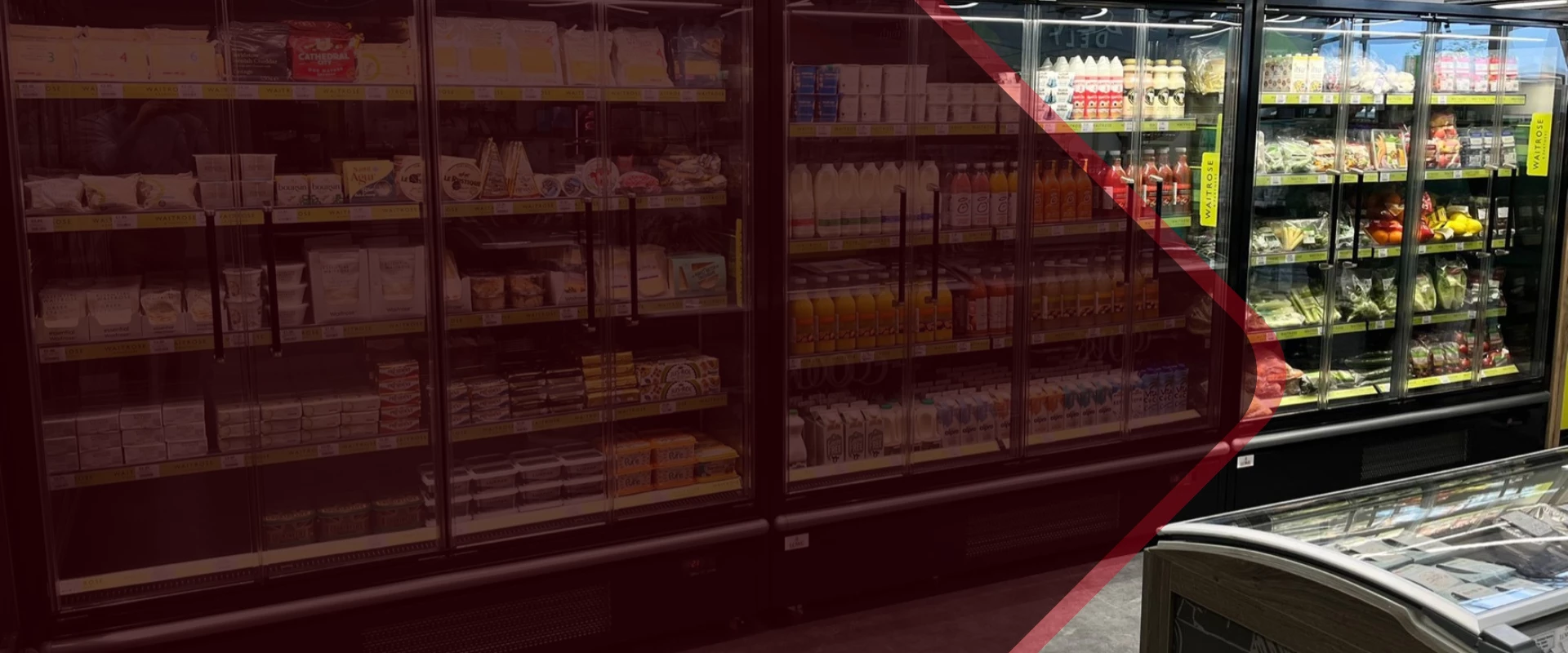 Refrigerated display case filled with various dairy products, including milk and cheese, in a store.