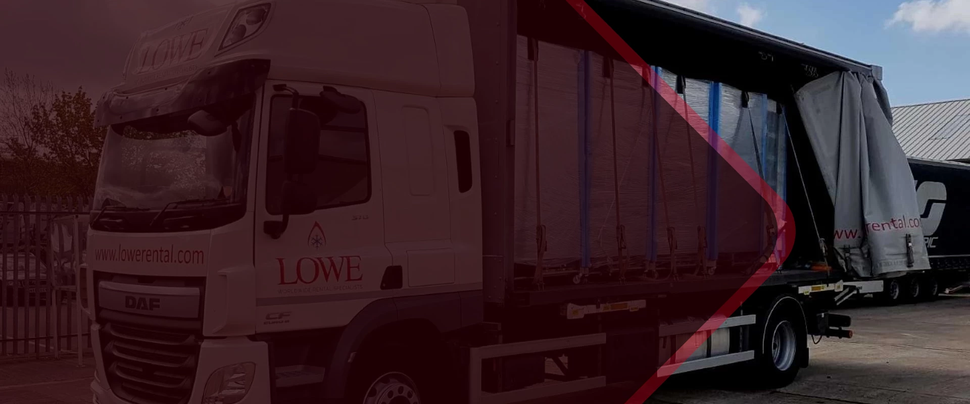 White truck with blue tarpaulin, partially obscured by red graphic, labelled 