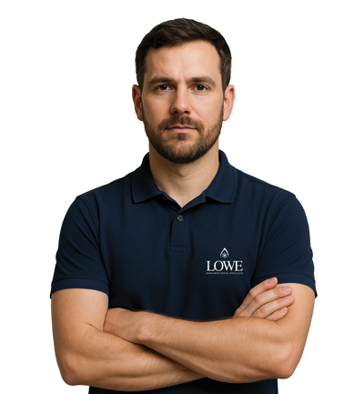 Man in a navy polo shirt with crossed arms, displaying a serious expression against a plain background.