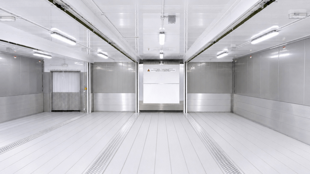 Bright, clean cold storage facility with white walls and floor, featuring metal sliding doors.