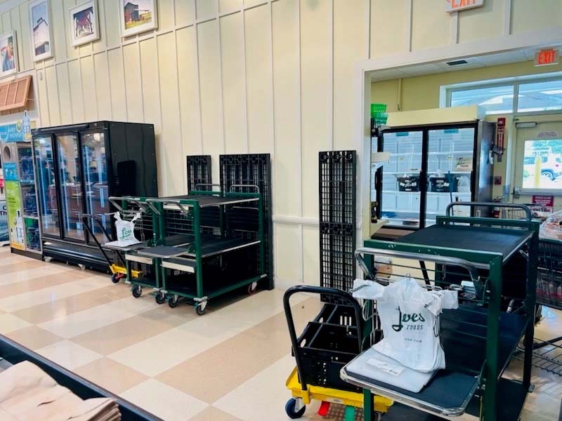 Ecommerce workspace featuring green carts, a white t-shirt, and a light-coloured tiled floor.