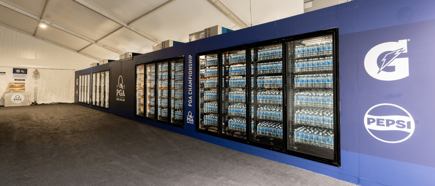 A large blue display fridge filled with bottled water, set against a grey floor.