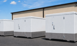 Ready-built cold rooms with white exteriors and grey bases against a blue sky backdrop.