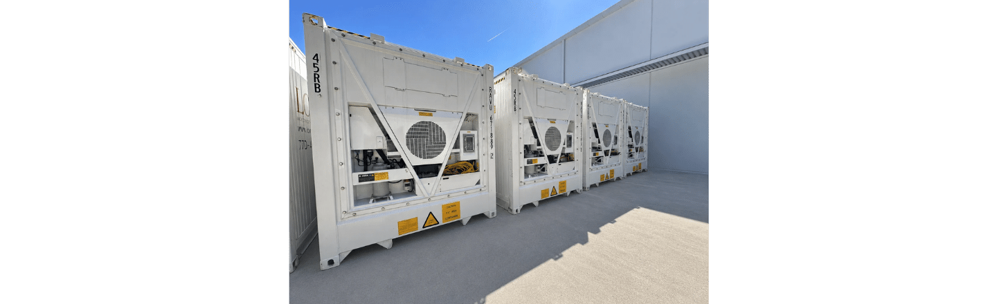 Three white refrigerated containers lined up against a clear blue sky, showcasing their cooling units.